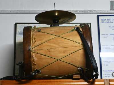 Mentre il presidente parla notiamo su un armadio un azzebb�nne, storpiatura dialettale dall�americano �One Man Band�: un tamburo che pu� definirsi una vera e propria orchestra itinerante suonata da una sola persona. Usato anche da Piripicchio, il leggendario artista di strada pugliese, permette di percuotere lo strumento anche usando gli arti inferiori, grazie a delle corde legate alle caviglie del suonatore